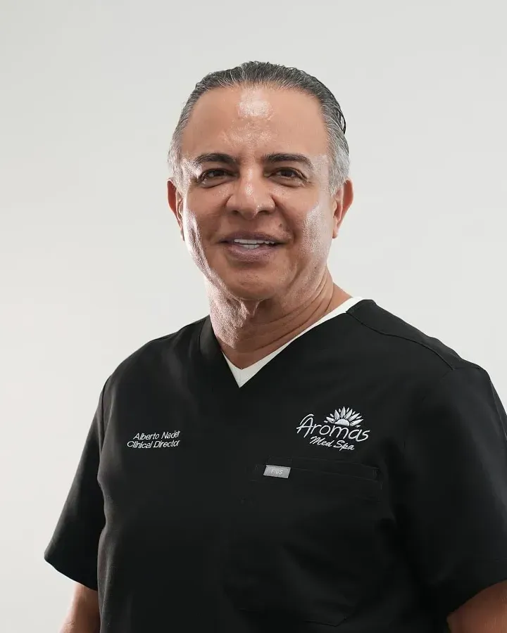 Alberto Nader, founder and Clinical Director of Aromas Med Spa in Doral, Florida, smiling in black Aromas scrubs