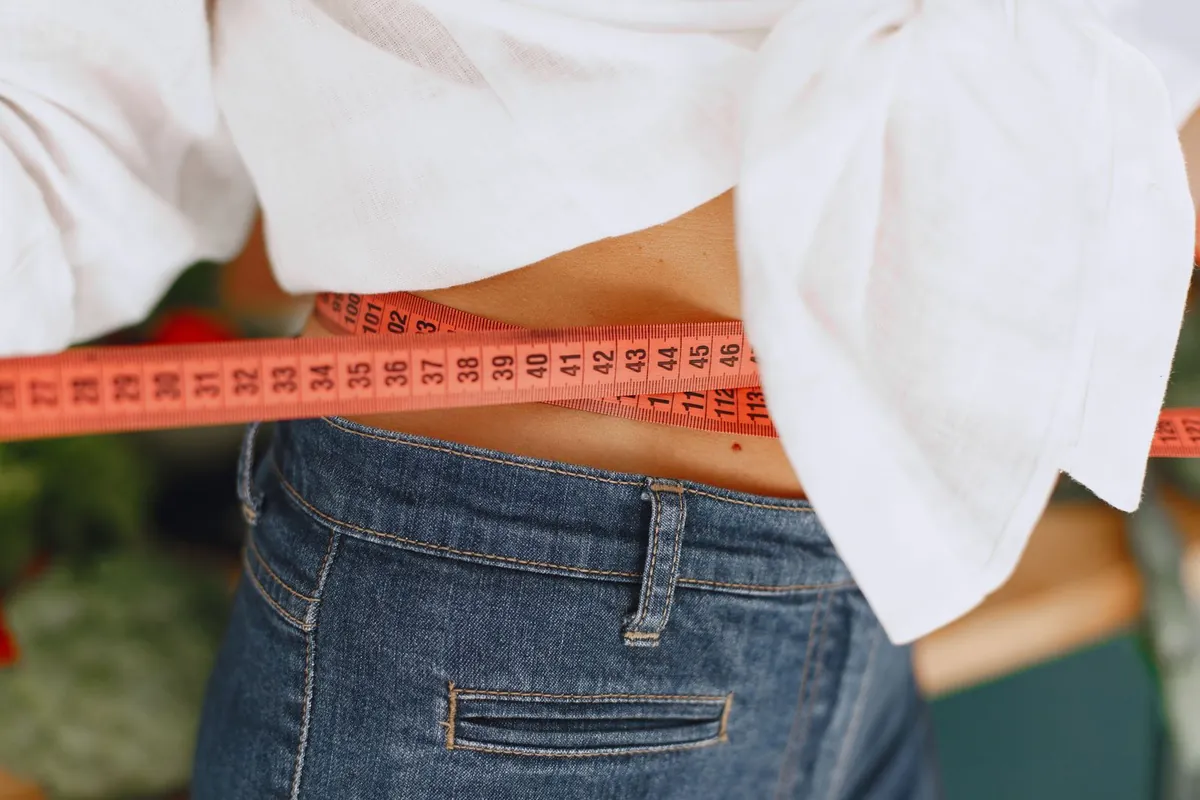 Close-up of a waist being measured with a tape measure